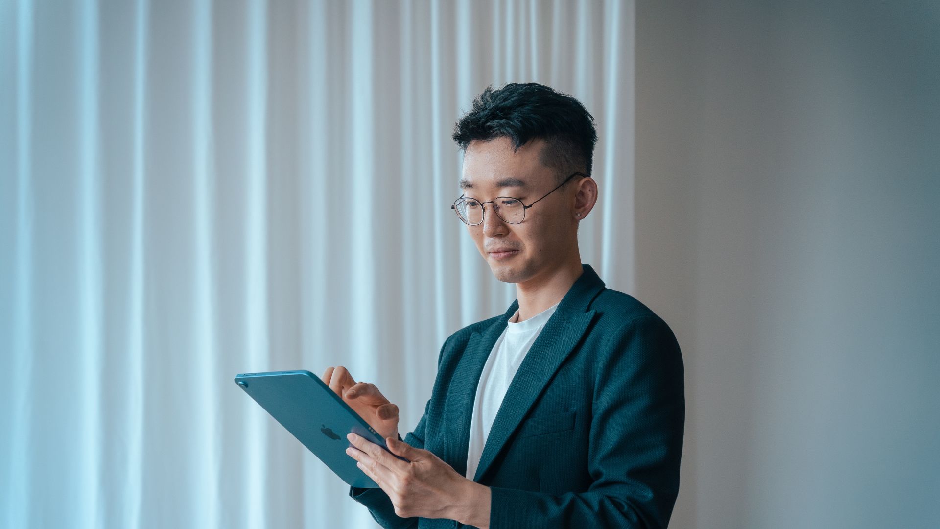 A man is looking at an Ipad that showcase Web Manuals