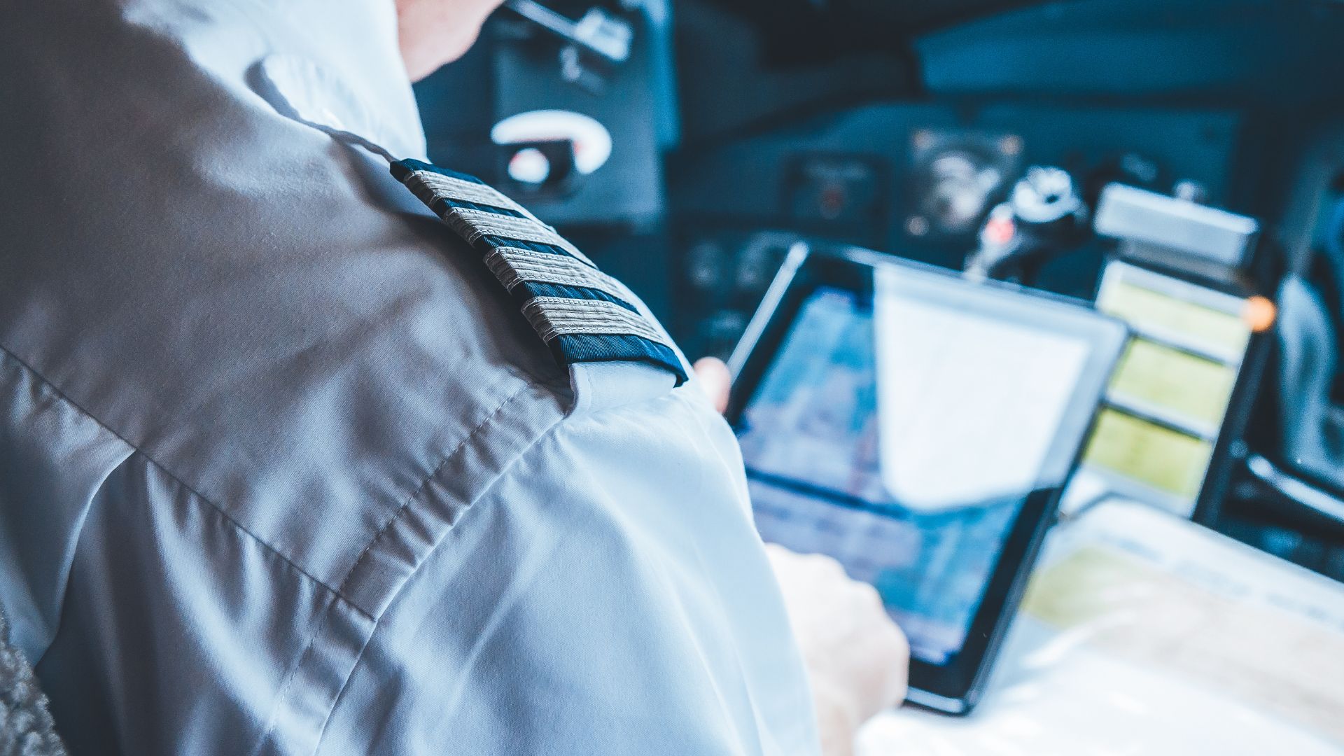 A pilot in the cockpit looking at an Ipad